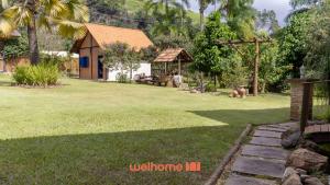 a house in a yard with a grassy yard at Chale Rustico com Vista para a Montanha in Venda Nova do Imigrante