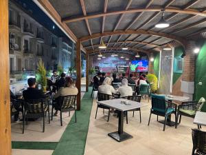 a group of people sitting at tables in a restaurant at Soft Hotel in Cairo