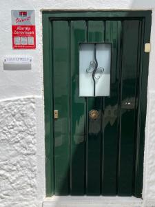 a green door with a pair of scissors on it at Casa Patricia I in Arcos de la Frontera