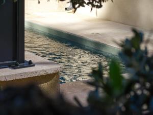 a pool of water next to a building at Villa Lynae in Saint-Restitut