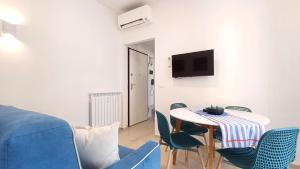 a living room with a table and chairs and a tv at Appartamento Conchiglia Blu di Pietra in Pietra Ligure