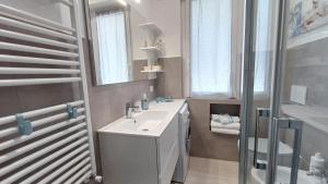 a bathroom with a sink and a mirror and a shower at Appartamento Conchiglia Blu di Pietra in Pietra Ligure +40 photos