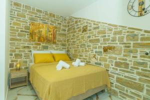 a bedroom with a bed with a brick wall at Bellus Residence 2! in Ambeloúzos
