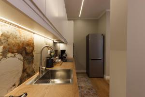 una cocina con fregadero y frigorífico en GjiroCasa Apartament, en Gjirokastra