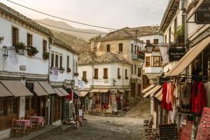un callejón en un casco antiguo con ropa y tiendas en GjiroCasa Apartament, en Gjirokastra