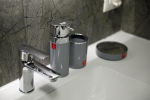 lavamanos con 2 tazas y grifo en GjiroCasa Apartament, en Gjirokastra 47 fotos más