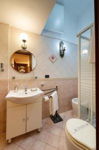 a bathroom with a sink and a toilet and a mirror at Sancta Scala in Rome