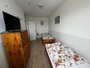 1 Schlafzimmer mit 2 Betten, einem TV und einer Kommode in der Unterkunft Urban Stay Marl in Marl