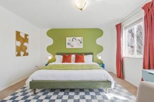 a bedroom with a bed with a green headboard at Spacious 4BD - Backyard BBQ, Fire Pit & Mini Golf in Arvada
