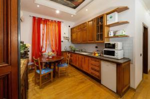 a kitchen with wooden cabinets and a table and a microwave at Sancta Scala in Rome +36 photos