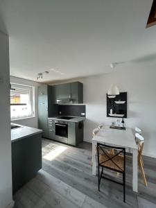a kitchen with a table and a white counter top at Boddenhus Loissin in Loissin