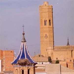 a building with a tower with a clock on it at Hotel El Patiaz de la Reina Rana in Tauste