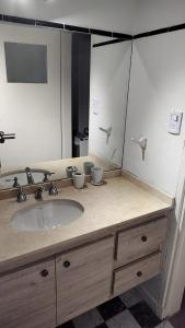 ein Badezimmer mit Waschbecken und großem Spiegel in der Unterkunft Amplia casa cerca del centro de la ciudad in Cordoba