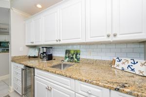 a kitchen with white cabinets and a sink at Phoenix on the Bay 1310 condo in Orange Beach