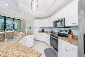 a kitchen with white cabinets and granite counter tops at Phoenix on the Bay 1310 condo in Orange Beach