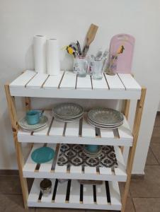 a white shelf with plates and dishes on it at Florida 68 B in Puerto Iguazú