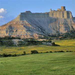 una montaña con un castillo encima de ella en Hotel El Patiaz de la Reina Rana, en Tauste