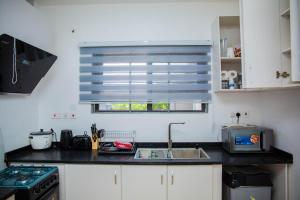 a kitchen with a sink and a stove and a window at No4 Wisdom Court in Accra
