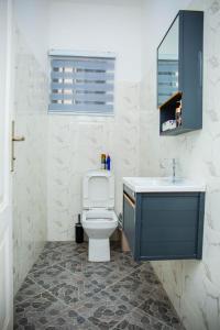 un baño con inodoro y lavabo en No4 Wisdom Court, en Accra