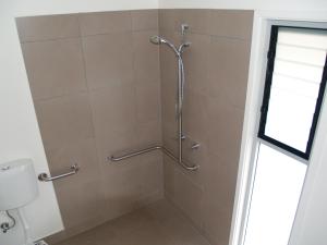 a shower in a bathroom with a tiled wall at Craggy Peaks in Rossarden