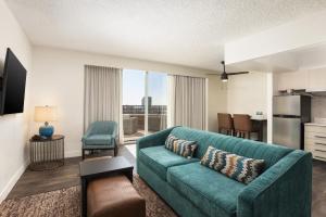 奥斯汀DoubleTree Suites by Hilton Austin Downtown Capitol的带绿色沙发的客厅和厨房