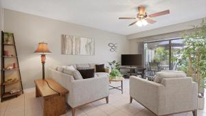 a living room with two chairs and a ceiling fan at Hale Lopaka at Kona Plaza in Kailua-Kona