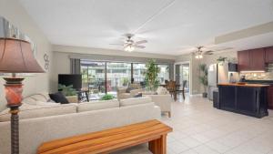 a living room with a couch and a table and a kitchen at Hale Lopaka at Kona Plaza in Kailua-Kona