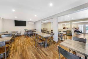 a restaurant with wooden tables and chairs and a flat screen tv at Best Western Plus Ontario Airport & Convention Center in Ontario