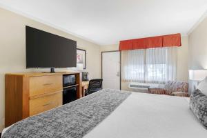 a hotel room with a bed and a flat screen tv at Best Western Plus Ontario Airport & Convention Center in Ontario