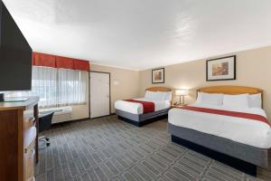 a hotel room with two beds and a flat screen tv at Best Western Plus Ontario Airport & Convention Center in Ontario