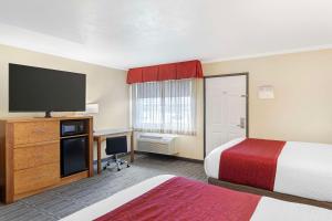 a hotel room with two beds and a flat screen tv at Best Western Plus Ontario Airport & Convention Center in Ontario