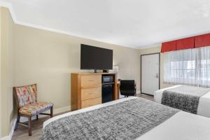 a hotel room with two beds and a flat screen tv at Best Western Plus Ontario Airport & Convention Center in Ontario