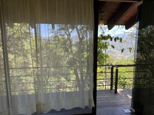 an open door to a porch with a white curtain at Cabaña de Vidrio en el Bosque in Pahuatlán del Valle +1 photo