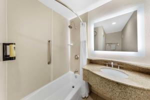 a bathroom with a sink and a tub and a mirror at Best Western Plus Ontario Airport & Convention Center in Ontario