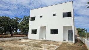 a white building with two doors on the side at Pousada Morada do Sol AP 01 in Três Marias