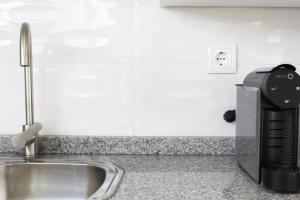 eine Küchentheke mit einer Kaffeemaschine neben einer Spüle in der Unterkunft Valbom Hideaway Light, Style and Peace in Valbom