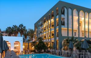 a hotel with a swimming pool in front of a building at Flower Hotels & Resorts in Golem