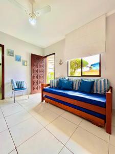 a large bedroom with a blue bed and a chair at Apê Ubahê Maranduba Ubatuba in Ubatuba