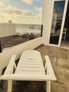 eine weiße Bank auf einem Balkon mit Meerblick in der Unterkunft Marina in La Santa