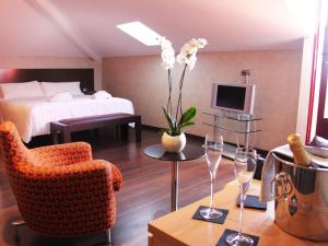 a hotel room with a bed and a couch and a chair at The Cookbook Gastro Boutique Hotel & SPA in Calpe