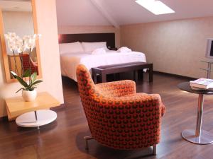 a hotel room with a bed and a chair at The Cookbook Gastro Boutique Hotel & SPA in Calpe