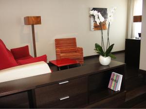 a living room with a couch and a red chair at The Cookbook Gastro Boutique Hotel & SPA in Calpe
