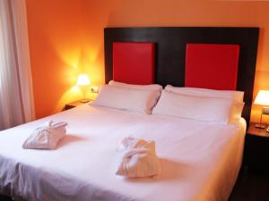 a bedroom with a white bed with two towels on it at The Cookbook Gastro Boutique Hotel & SPA in Calpe