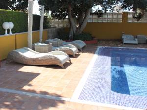 a row of lounge chairs next to a swimming pool at The Cookbook Gastro Boutique Hotel & SPA in Calpe