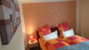 1 dormitorio con 2 camas y almohadas coloridas en Crosta Brava, en Großdubrau