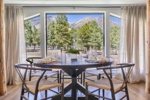 a dining room with a table with chairs and a large window at Relaxing Mountain Haven by Nature's Doorstep in Flagstaff