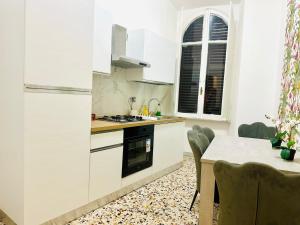 a kitchen with white cabinets and a table with chairs at Rome Termini Down-town Accommodation in Rome