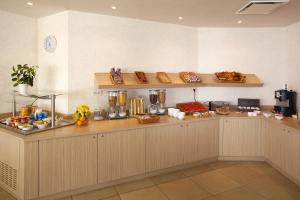 a kitchen with a counter with food on it at Residhome du Théâtre in Valenciennes