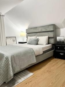 a bedroom with a large bed with a gray headboard at Charming beautiful house 7mn to downtown Ottawa in Gatineau
