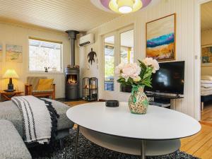 un salon avec un vase de fleurs sur une table dans l'établissement Exciting Cottage by the Sea - By Traum Ferienwohnungen, à Udsholt Sand